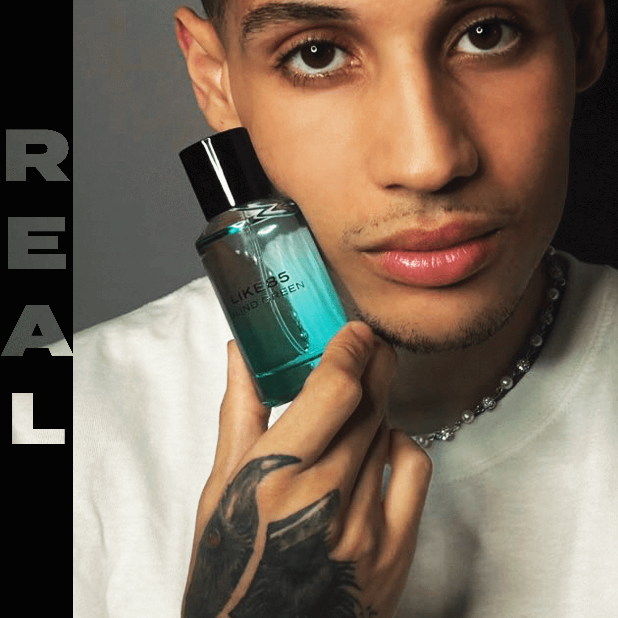 male model with tattoo holding Blind Green fragrance bottle 50ML